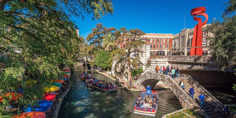 boat on the San Antonio Riverwalk, showcasing lively architecture